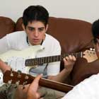 beginner taking in home guitar lesson with private teacher